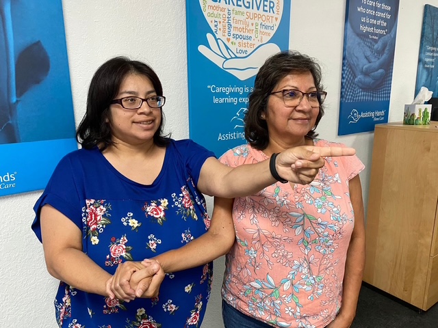 Two care partners practicing Hand-under-Hand ® support