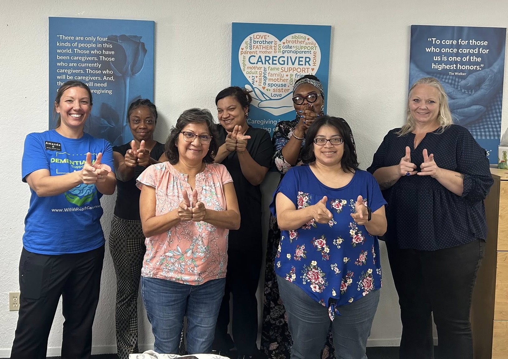Amanda with a group of caregivers giving finger points after a training session